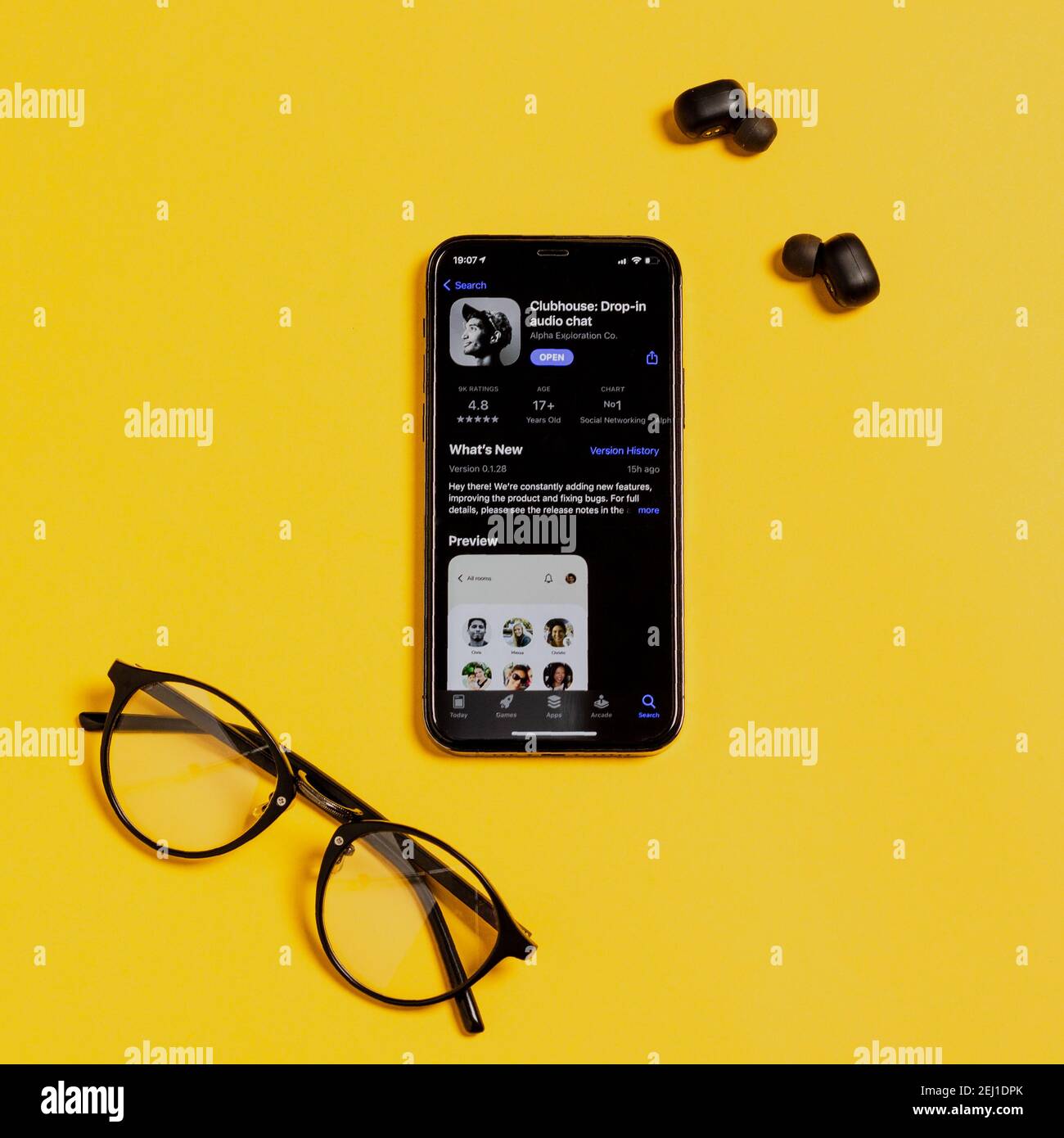 Moskau, Russland - 16. Februar 2021. Apple iPhone 12 Pro mit Clubhouse-Anwendung, Kopfhörer, Brille auf beleuchtenden Hintergrund von 2021. Social-Media-App Stockfoto