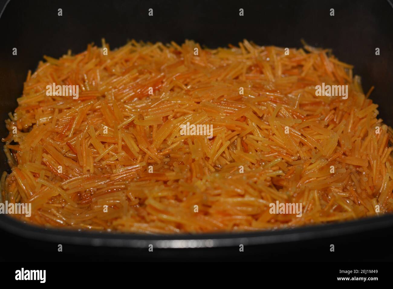 Gebräunt in Butter süß ägyptischen vermicelli mit Wasser und Zucker in einem Kochtopf gekocht,. Traditionelle ägyptische Dessert in späten Mittag-und frühen Abendessen Stockfoto