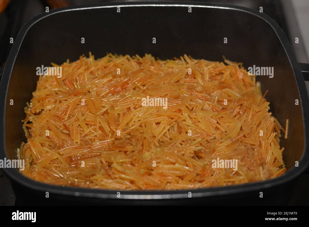 Gebräunt in Butter süß ägyptischen vermicelli mit Wasser und Zucker in einem Kochtopf gekocht,. Traditionelle ägyptische Dessert in späten Mittag-und frühen Abendessen Stockfoto