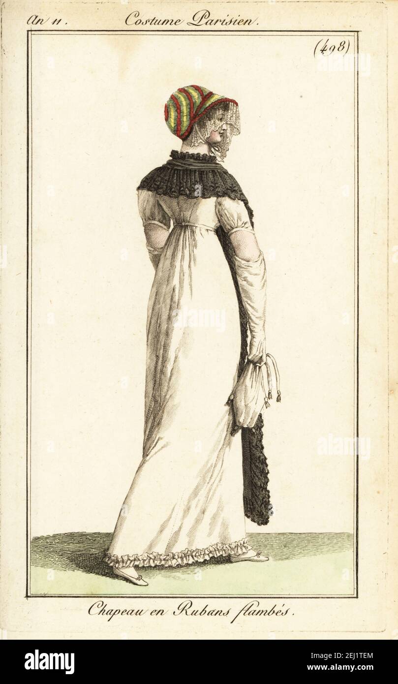 Modische Frau in bunten Band Haube. Sie trägt ein weißes Kleid, einen langen Spitzenschal und hält eine Spott-Tasche mit Kordelzug. Chapeau en Rubans flambés. Handkolorierter Kupferstich aus Pierre de la Mesangeres Journal des Dames et des Modes, Magazine of Women and Fashion, Paris, an 11, 1803. Illustrationen von Carle Vernet, Jean-Francois Bosio, Dominique Bosio und Philibert Louis Debucourt, gestochen von Pierre-Charles Baquoy. Stockfoto