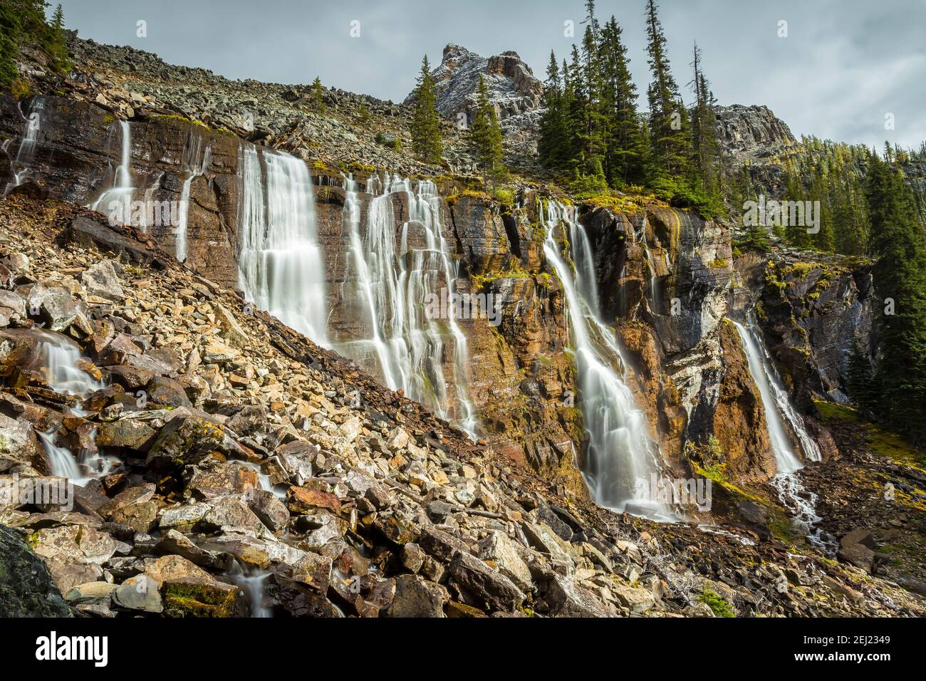 Lange Exposition von sieben Wasserfällen im Herbst, umgeben von felsigen Bergen und Bäume, Lake O'Hara, Yoho Nationalpark, British Columbia, Kanada Stockfoto