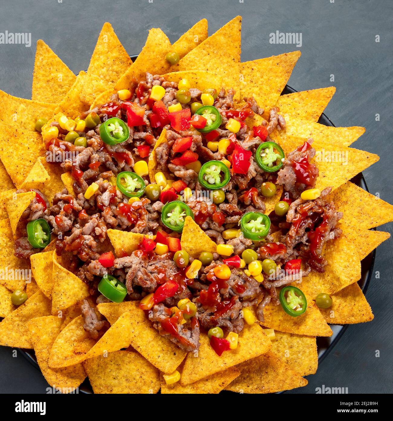 Köstliche hispanisch-mexikanische Speise-Pension mit Nachos, Rindfleisch, Guacamole, Avocado und Starfruit. Scharf und würzig Stockfoto