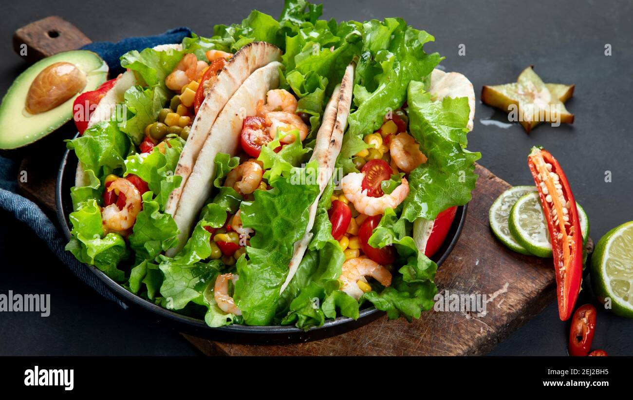Köstliche hispanisch-mexikanische Speise-Tafel mit Tacos, Guacamole, Garnelen, Avocado und Starfruit. Scharf und würzig Stockfoto