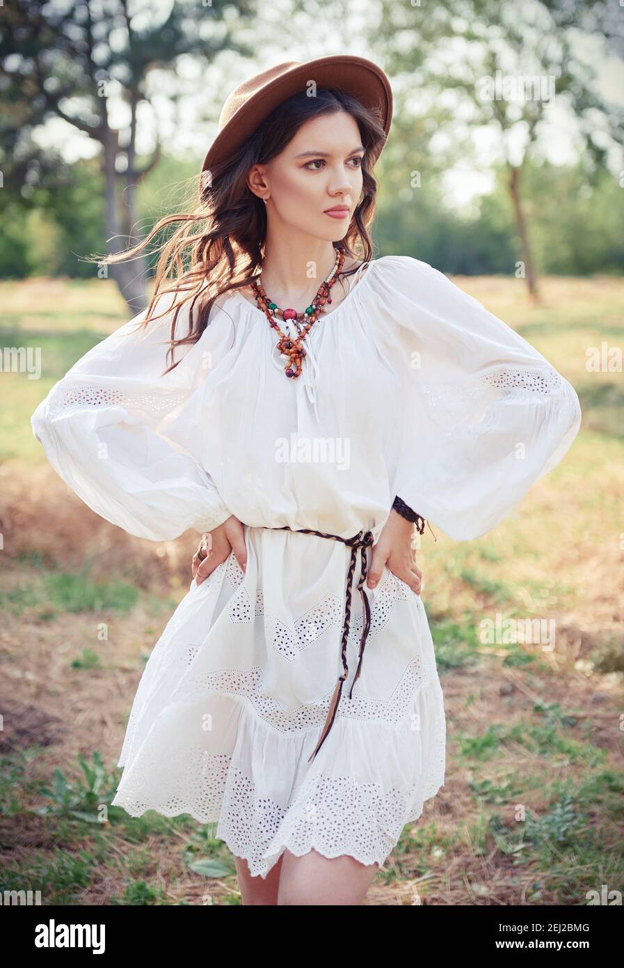 Outdoor-Mode: Das schöne junge Boho (Hippie) Mädchen in Hain (Wald).  Porträt von süßen Hippie Frau in weißem Kleid und Hut Stockfotografie -  Alamy