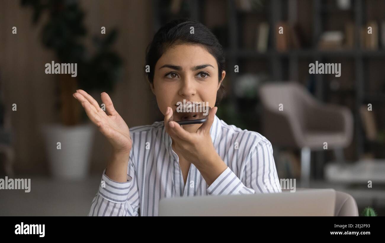 Indische Frau sprechen über Lautsprecher auf dem Smartphone Stockfoto