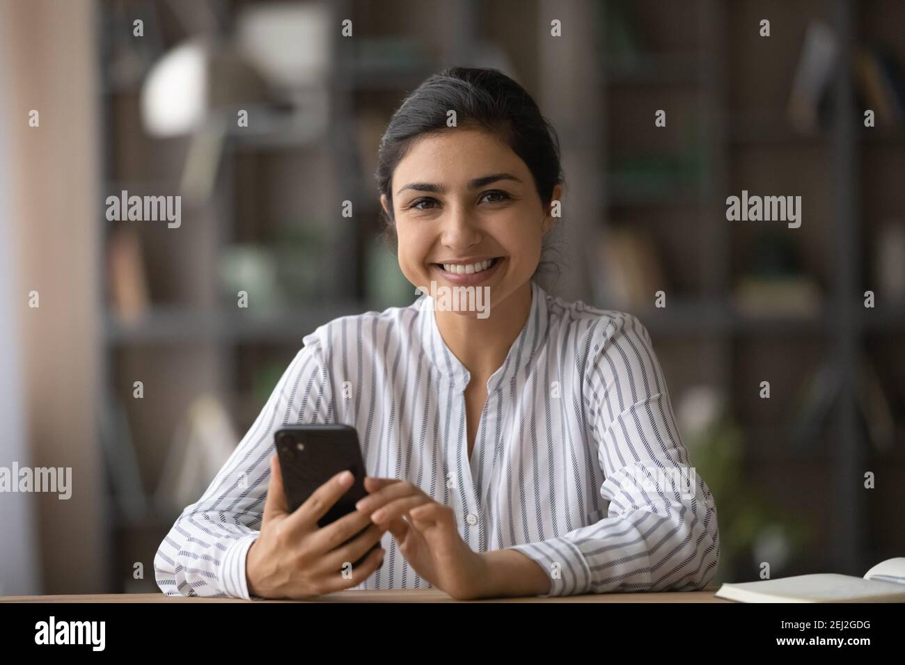 Portrait der lächelnden indischen Frau verwenden Handy Stockfoto