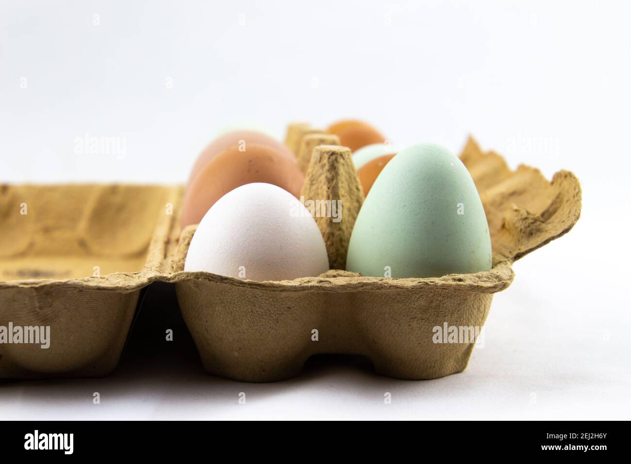 Grüne, braune und weiße Eier in einer Eierbox Stockfoto