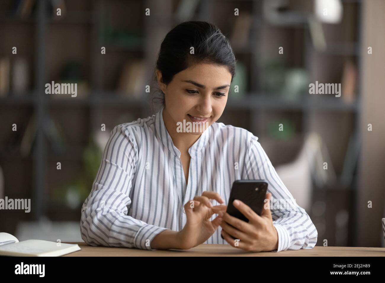 Glückliche indische Frau verwenden Handy-SMS online Stockfoto