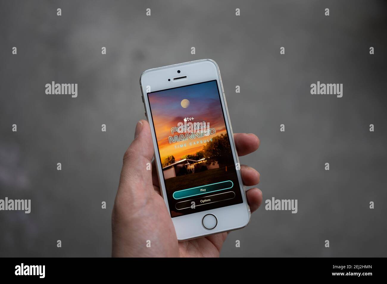 Ein Mann spielt das neue Augmented-Reality-Spiel "for All Mankind: Time Capsule" auf seinem iPhone. Die AR Experience basiert auf dem Apple TV+ Space Drama. Stockfoto