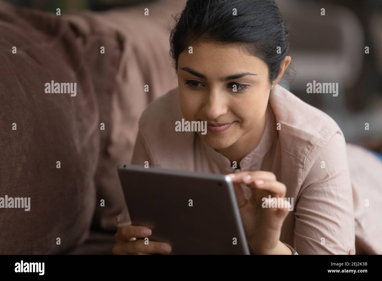 Happy Millennial indische Frau verwenden Tablet Texting Stockfoto