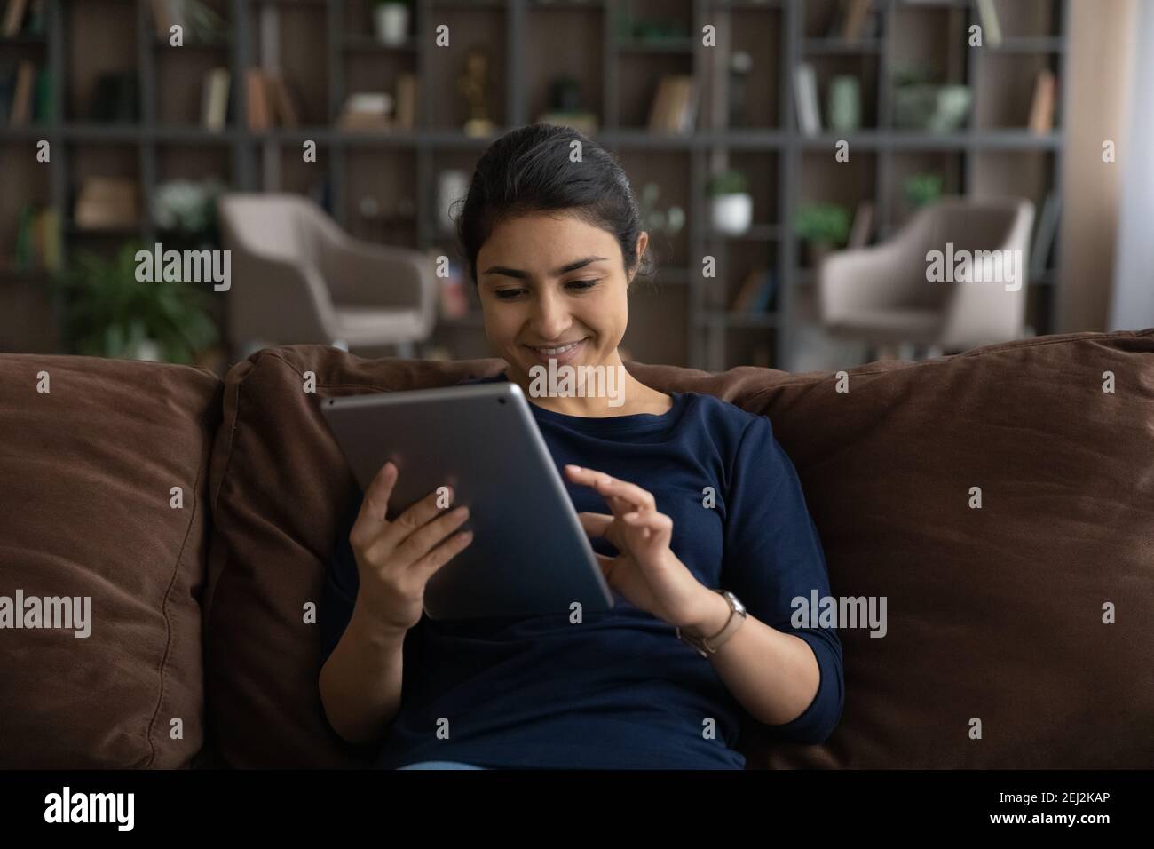Glückliche indische Frau Verwenden Sie Tablet-SMS online Stockfoto