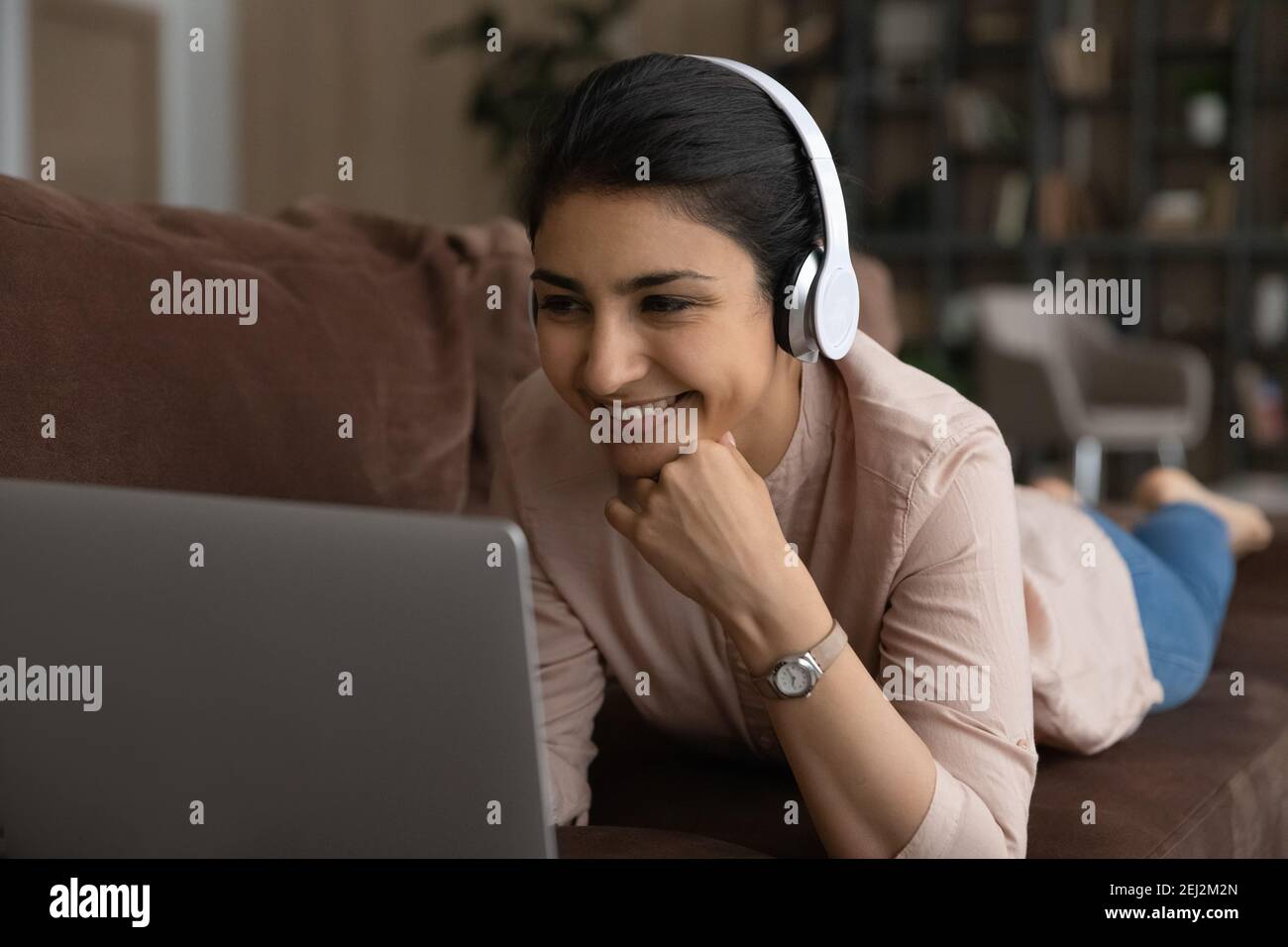 Glückliche indische Frau zu Hause mit Laptop entspannen Stockfoto