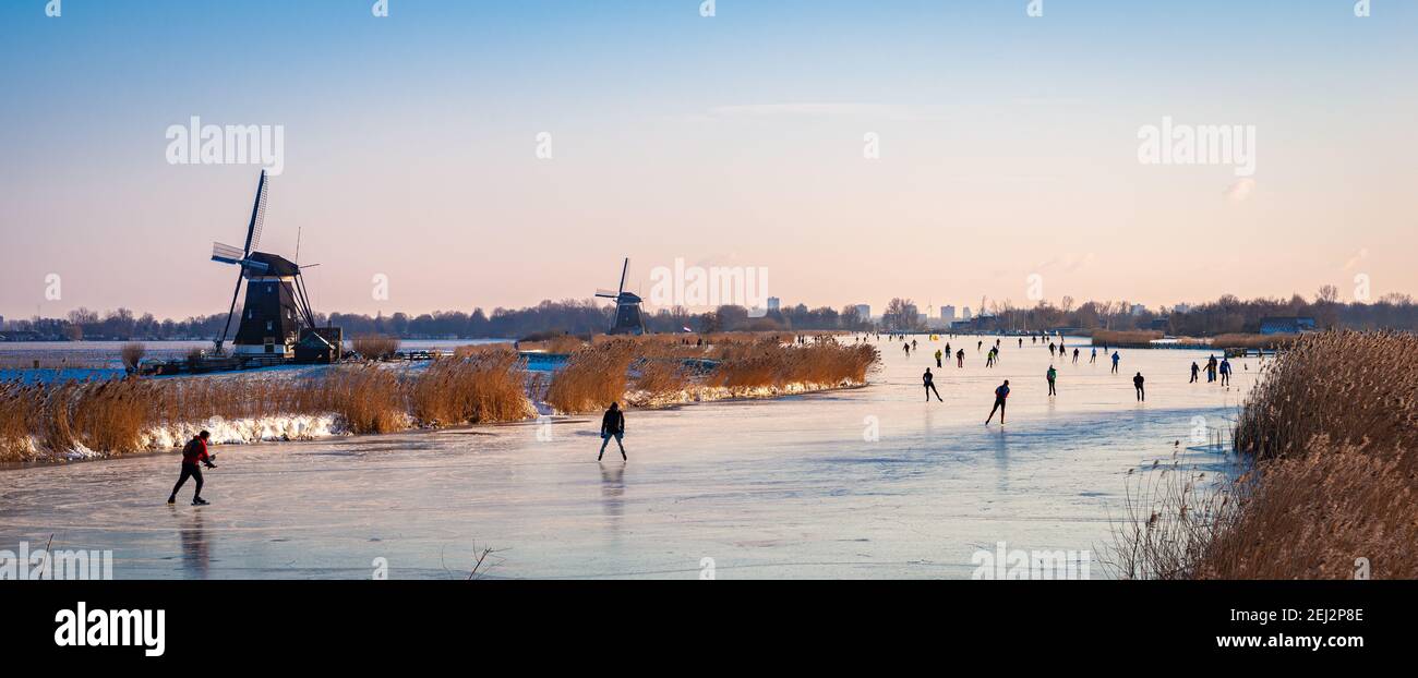 Klassische holländische Szene mit Eisläufern auf einem See während einer kalten Jahreszeit im Winter. Stockfoto
