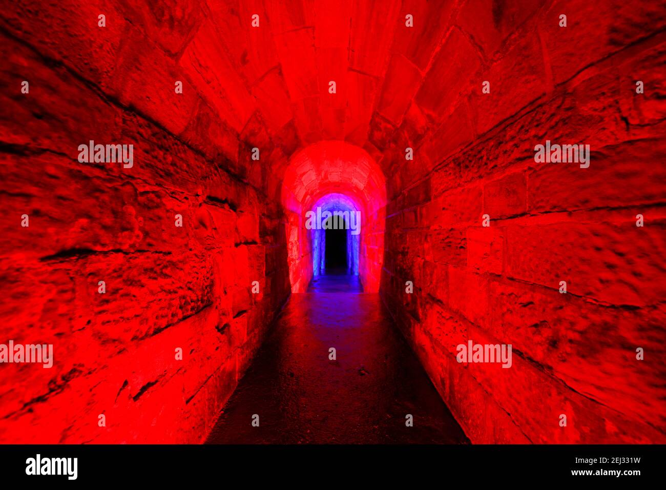 Ein Wasserüberlauftunnel aus einem See bei Temple Newsam in Leeds. Der Tunnel wurde mit einem RGB-Handlicht beleuchtet. Stockfoto