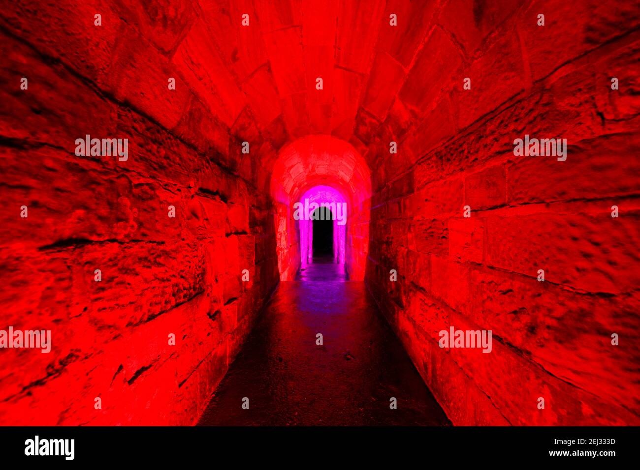 Ein Wasserüberlauftunnel aus einem See bei Temple Newsam in Leeds. Der Tunnel wurde mit einem RGB-Handlicht beleuchtet. Stockfoto