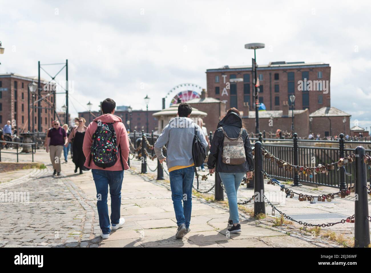 Drei Touristen Freunde auf dem Rücken mit Rucksäcken zu Fuß in Das Royal Albert Dock von Liverpool Stockfoto