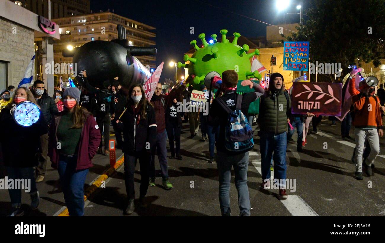 JERUSALEM, ISRAEL - 20. FEBRUAR: Demonstranten tragen eine riesige Nachstellung eines Coronavirus und große U-Boot-Nachstellung (in Bezug auf die sogenannte U-Boot-Affäre ein massiver angeblicher Bestechungsskandal bei der Beschaffung) während einer Demonstration in der Nähe des offiziellen Wohnsitzes des Premierministers am 20. Februar 2021 in Jerusalem, Israel. Die Demonstranten fordern seit Monaten den Rücktritt Netanjahus, unter Berufung auf den Umgang seiner Regierung mit der Coronavirus-Pandemie und anhaltende rechtliche Probleme. Netanjahu steht vor Gericht wegen Bestechung, Betrug und Verletzung des öffentlichen Vertrauens, über die er vehement jegliches Fehlverhalten leugnet. Stockfoto