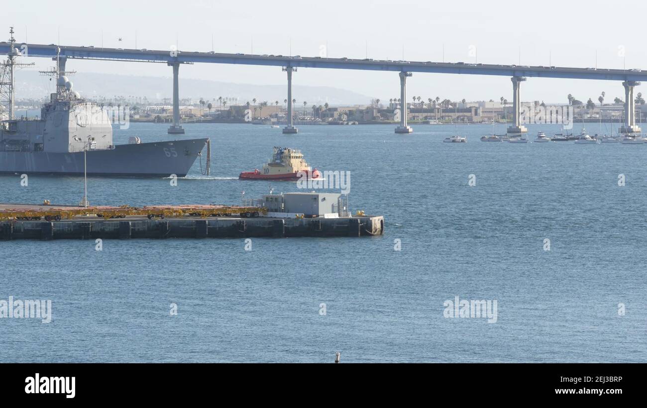 SAN DIEGO, CALIFORNIA USA - 13 FEB 2020: Schlepper ziehen USS Chosin CG-65, Militärschiff der US Navy Flotte. Schlepper Schleppen maritimes Schlachtschiff in Port h Stockfoto