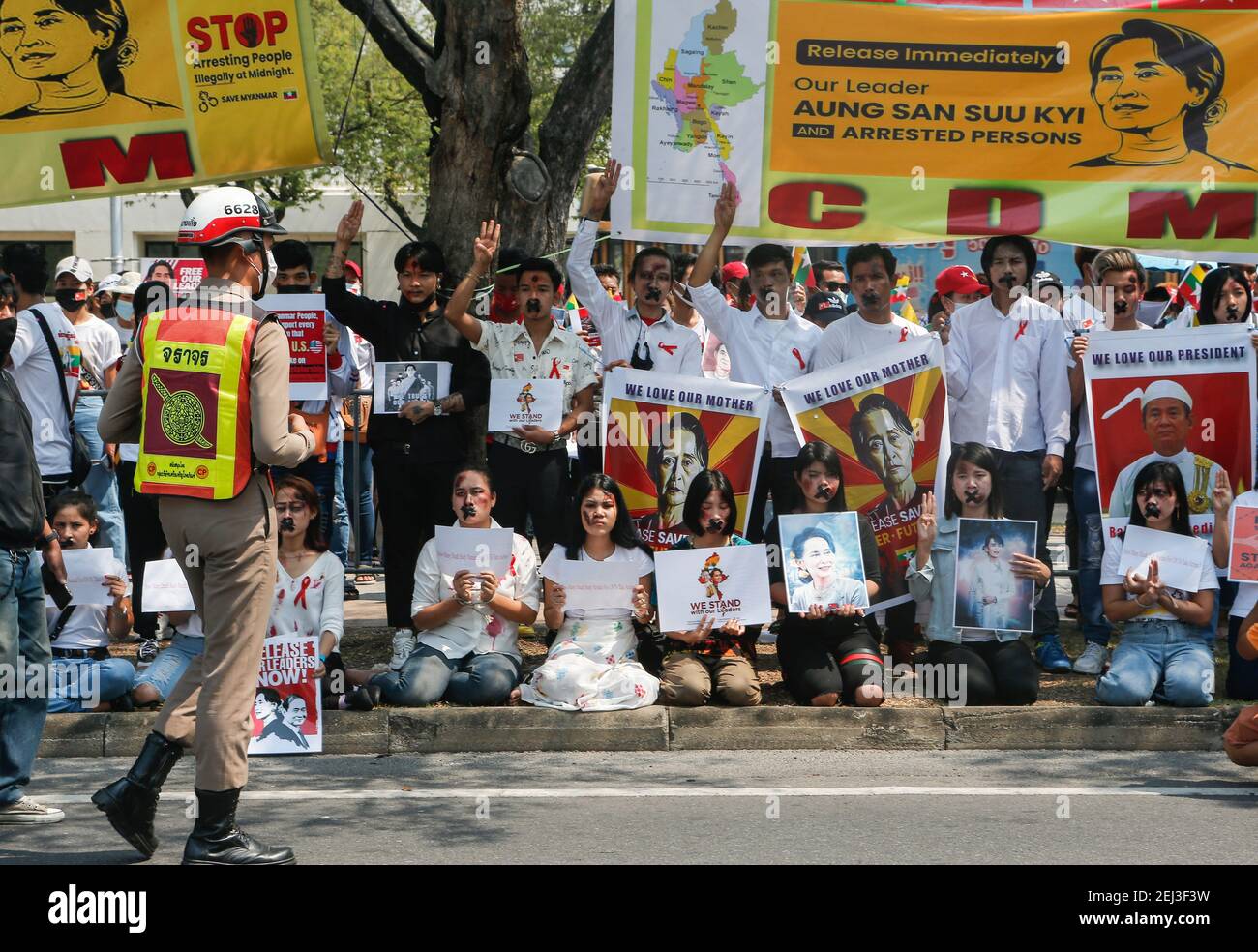 Myanmar Bürger leben in Thailand kreuzten ihren Mund, während sie Plakate mit den Bildern der Führerin Aung San Suu Kyi während der Demonstration halten. Demonstranten versammelten sich vor dem Gebäude der Vereinten Nationen, um gegen den Militärputsch zu protestieren und forderten die Freilassung von Aung San Suu Kyi. Das Militär von Myanmar nahm am 01. Februar 2021 die staatliche Beraterin von Myanmar Aung San Suu Kyi fest und erklärte den Ausnahmezustand, während sie die Macht im Land für ein Jahr ergattete, nachdem sie die Wahl gegen die National League for Democracy (NLD) verloren hatte. Stockfoto