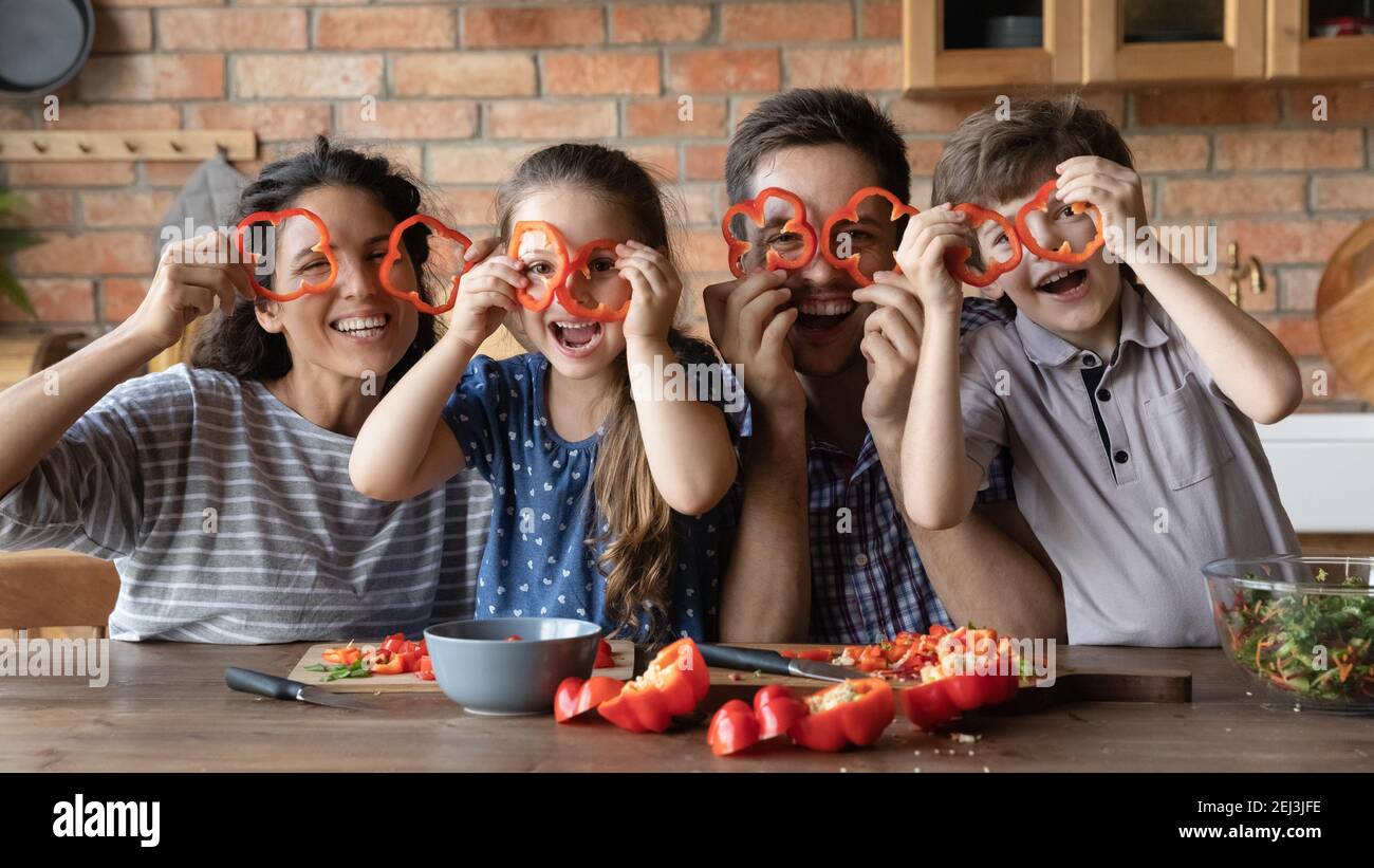 Lustige Porträt glücklich Familie hält roten Pfeffer Kreise als Gläser Stockfoto