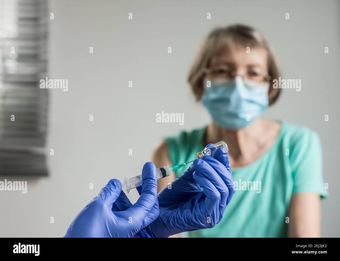 Arzt gibt einer älteren Frau eine Impfung. Virenschutz. COVID-2021. Stockfoto