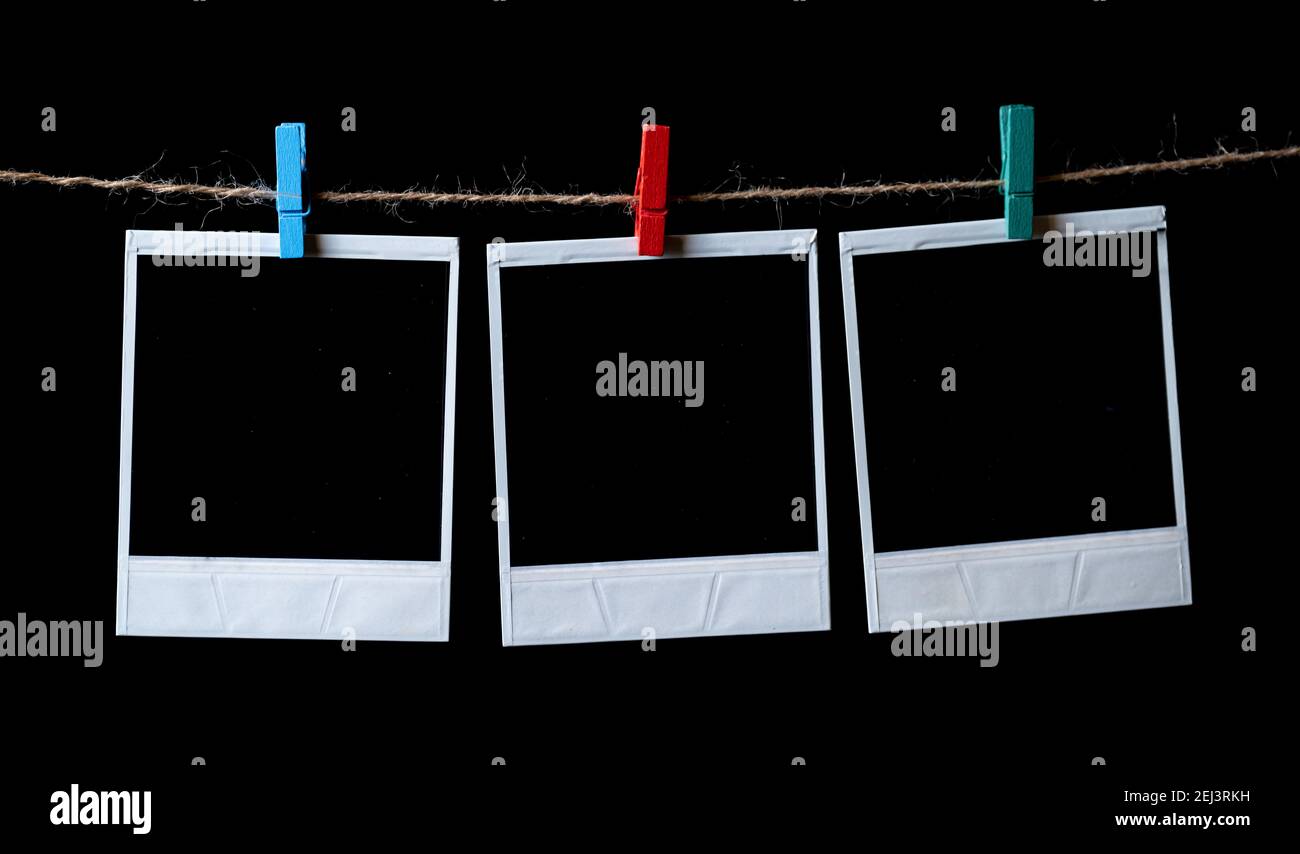 Leere quadratische Bilderrahmen, die an einer Wäscheleine hängen Stockfoto