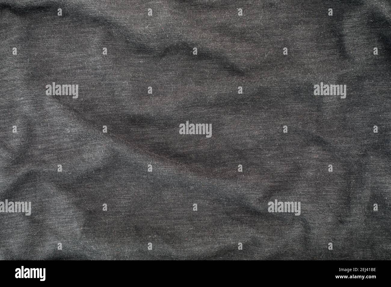 Dunkelgraue Baumwoll-Stoffstruktur. Kleidung Baumwolle T-Shirt Hintergrund mit Falten. Flache Lay-Ansicht von oben. Stockfoto