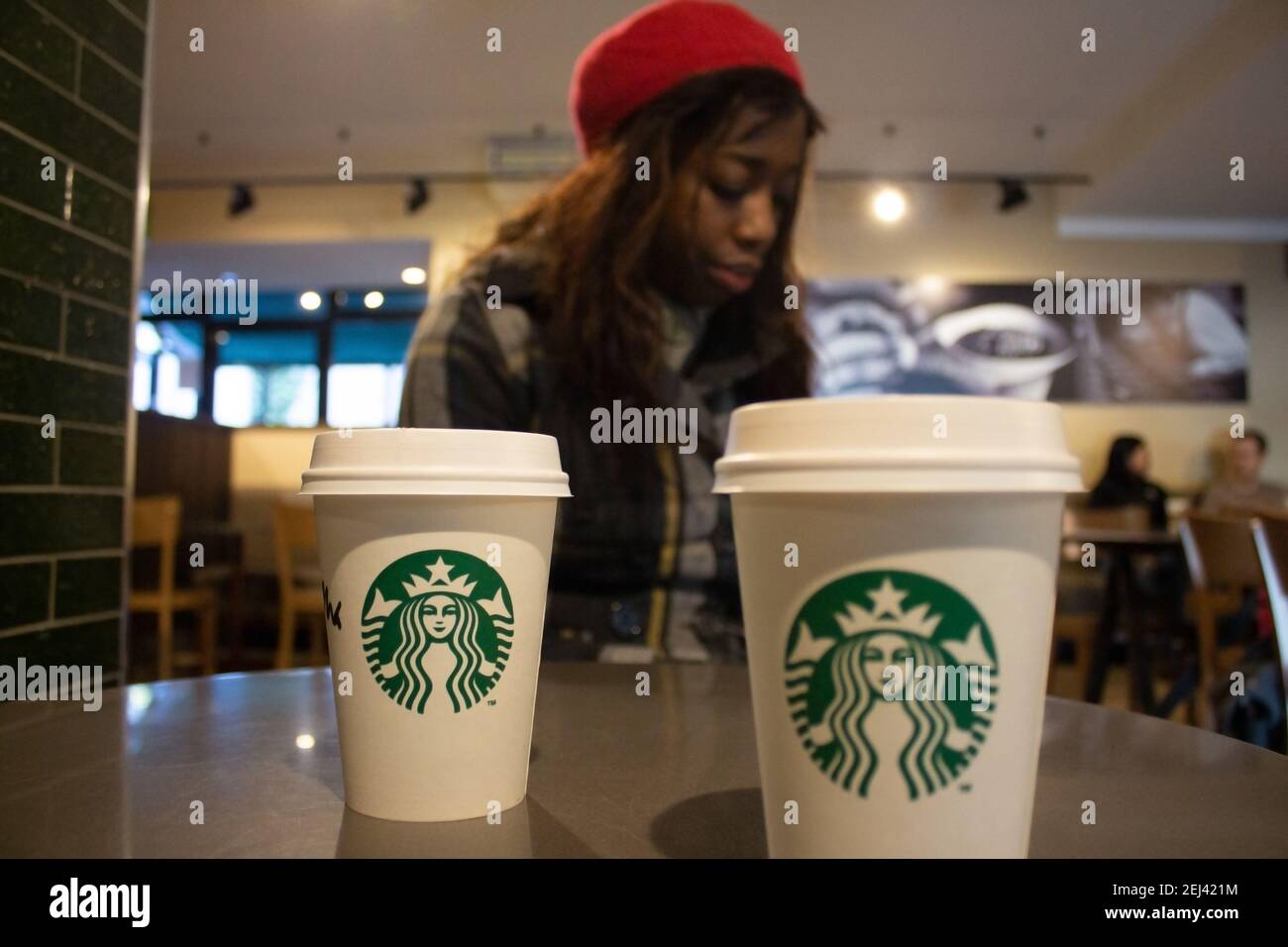 Nahaufnahme von Starbucks Kaffeetassen, die auf einem Tisch in einem Kaffeehaus platziert sind. Starbucks serviert heiße und kalte Getränke, Espresso, Caffe Latte. Stockfoto