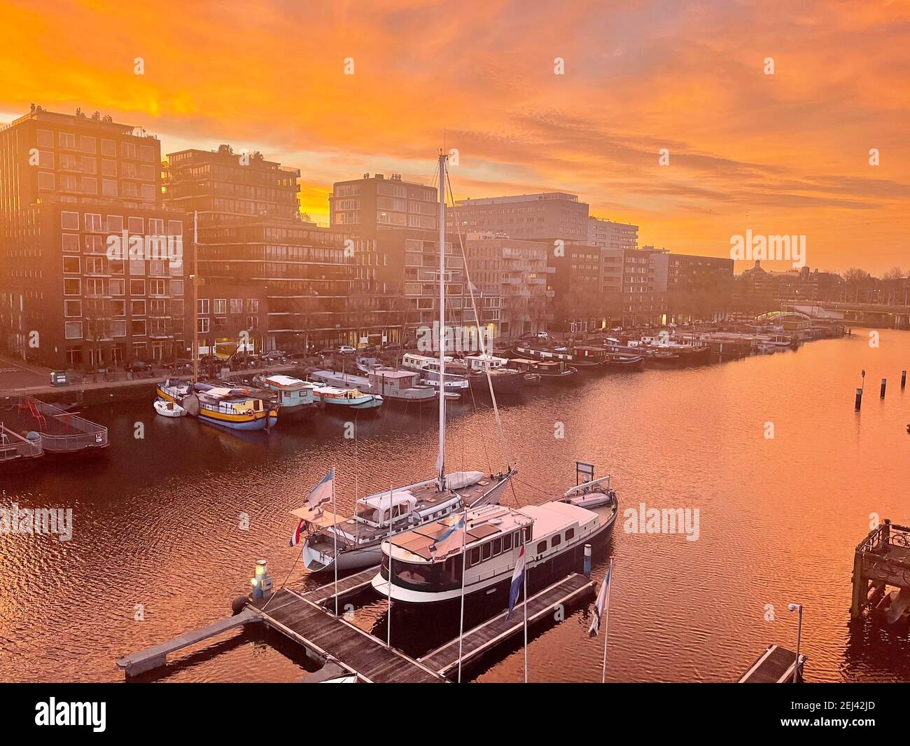 Die Niederlande beginnen das Frühjahr 2021 im februar Amsterdam Am 02-21-2021 mit rotem Morgenglühen am Himmel Dämmerung um 07,30 Stockfoto