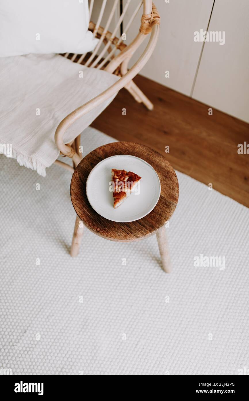 Ein Stück hausgemachten Apfelkuchen auf einem Holz Hocker im Wohnzimmer Stockfoto