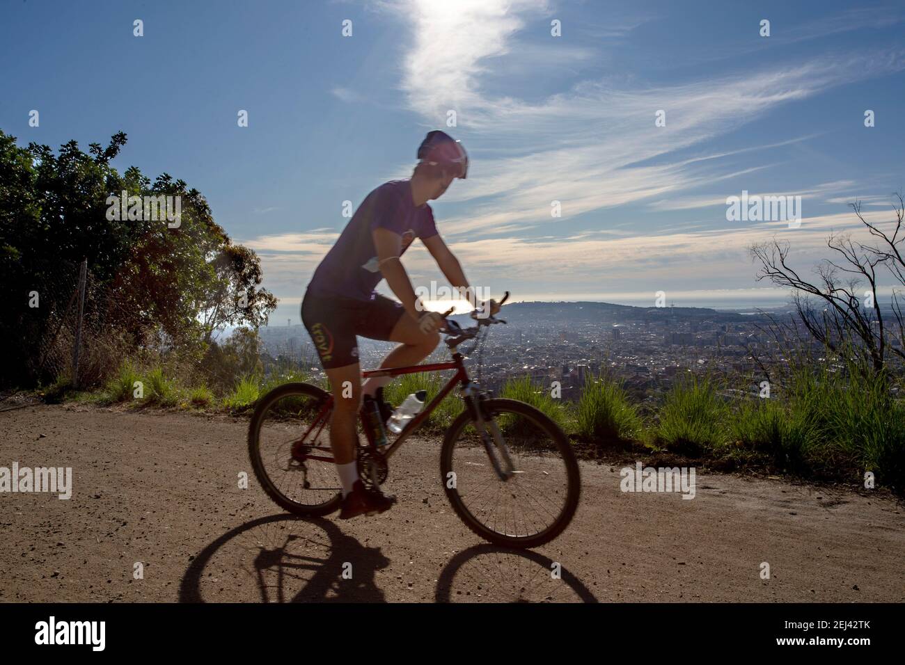 Ciclista disfruta de la vista de Barcelona desde las carretera de las aigues. Gracias a su estenxion se puede ver toda la ciudad desde punto diferent Stockfoto