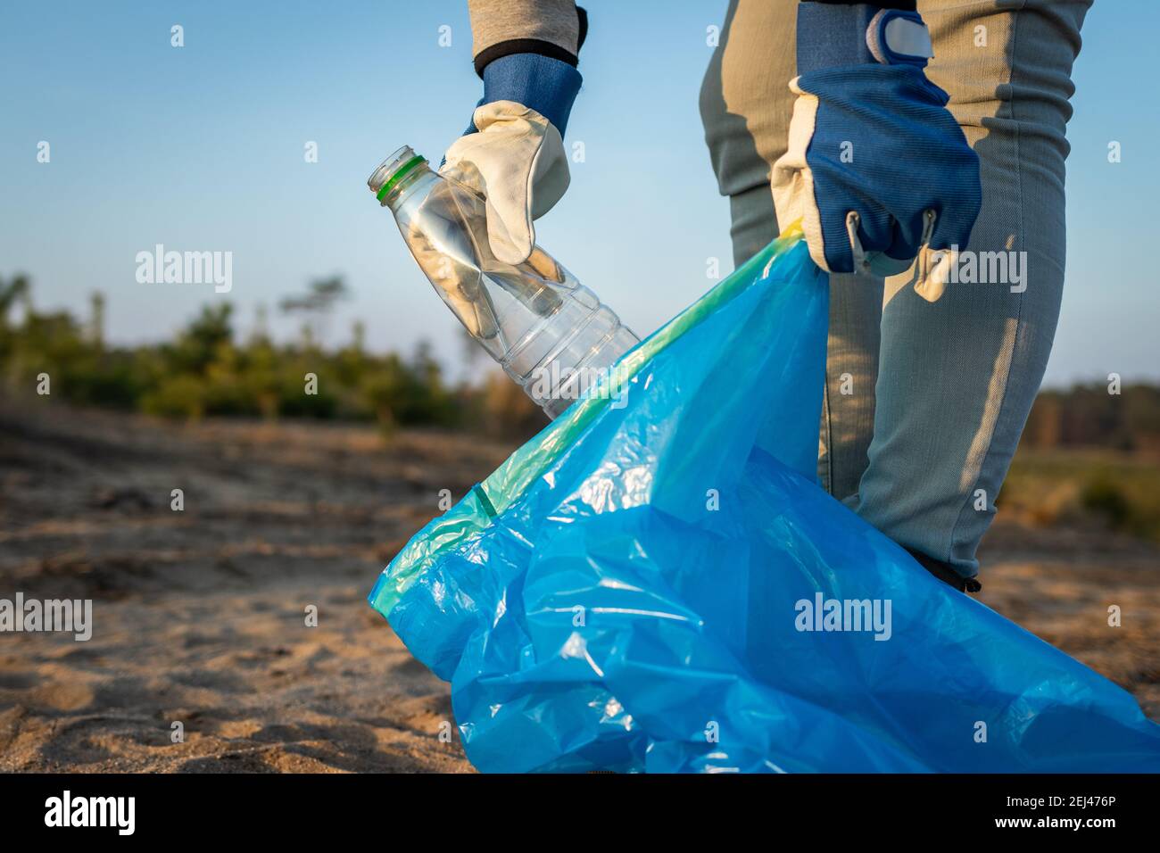 Die Menschen müssen Verantwortung übernehmen! Verschmutzung durch Plastik. Aktivist Reinigung Strand von Plastikmüll. Umweltbereinigung. Macht die Erde sauber! Stockfoto