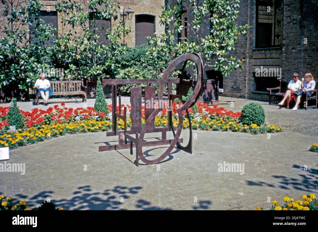 Eine Stahlskulptur von 1989, Nigel Halls ‘Clerestory’, in der City of London, England, UK 1993. Dies war Teil der ‘Art in the City’ von 1993 und zielte darauf ab, Skulpturen zwischen den Grünflächen und der unverwechselbaren Architektur der City of London zu setzen. Nigel Hall RA (geb. 1943) ist einer der bekanntesten Bildhauer Großbritanniens. Seine Arbeiten, hauptsächlich aus Holz oder Stahl, beschäftigen sich mit dreidimensionalem Raum, Masse und Linie. Eine Maquette-Version dieser Skulptur ‘Clerestory’ aus Messing ist Teil der permanenten Kunstsammlung der britischen Regierung. Stockfoto