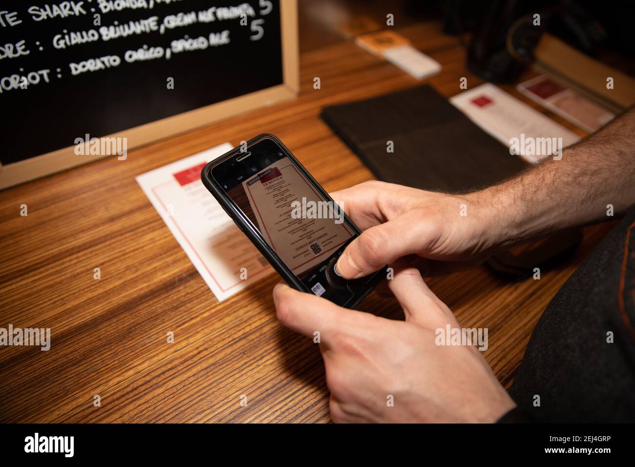 Der Kunde nutzt den QR-Code mit seinem Smartphone, um während der Coronavirus-Pandemie auf das Online-Menü des Restaurants zuzugreifen. Stockfoto