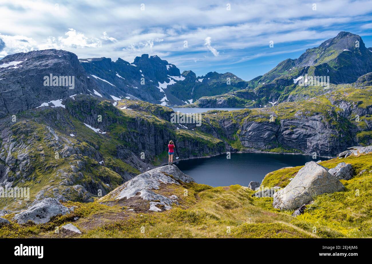 See Tennessvatnet und Krokvatnet, Wanderer steht auf Felsen, in der Nähe Munkebu Hütte, Berge, in der Nähe Sorvagen, Moskenesoya, Lofoten, Nordland, Norwegen Stockfoto