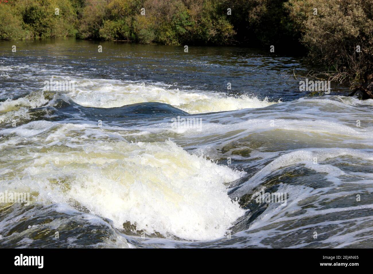 Der Bergfluss fließt über die Felsen sprudelnd und schäumend. Stockfoto