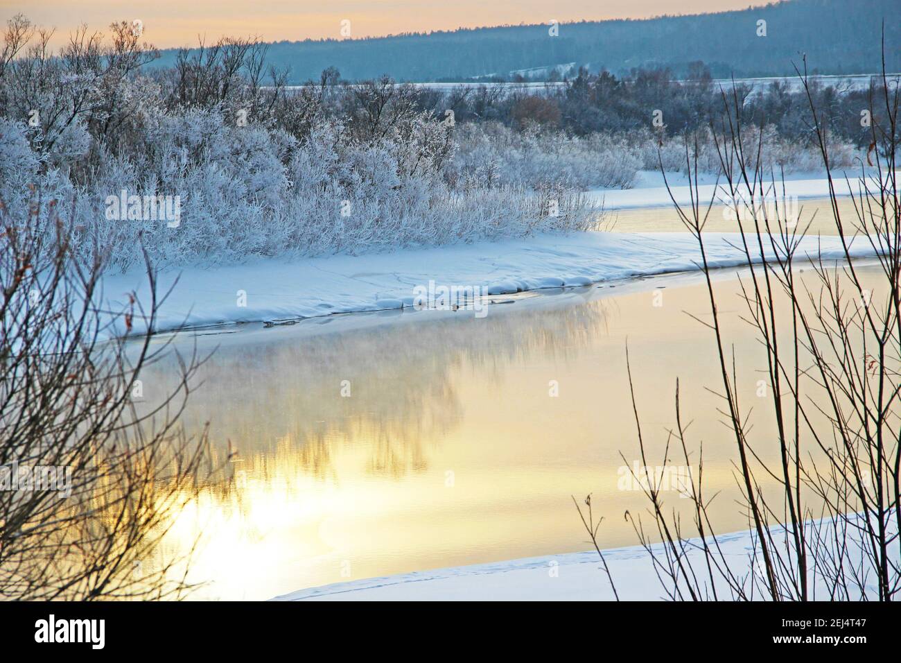 Winter Fluss läuft zwischen schneebedeckten Küsten und der Himmel Reflexion schafft einfach fantastische Landschaft. Stockfoto