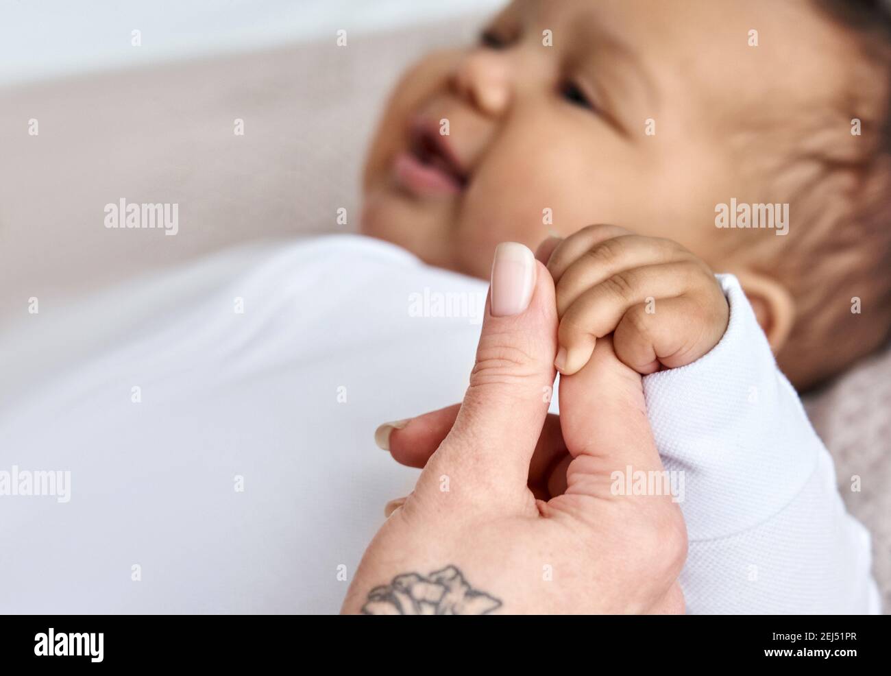 Hand der kaukasischen Mutter, Pflege Elternteil halten Hand der afrikanischen Baby Mädchen Tochter. Stockfoto