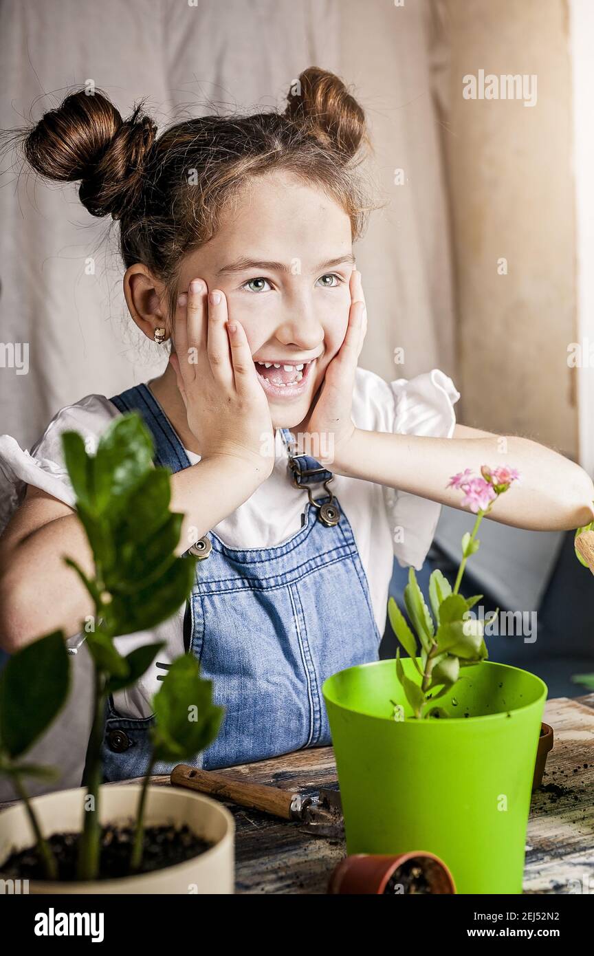 Cute fröhlich kaukasischen Mädchen lacht während der Gartenarbeit. Frühling Blume Pflanzen mit Kindern. Glückliche Momente. Vorderansicht. Close-up. Stockfoto