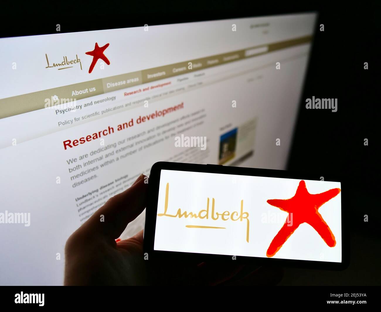 Person, die Mobiltelefon mit Geschäftslogo des dänischen Pharmaunternehmens H. Lundbeck AUF dem Bildschirm vor der Website hält. Konzentrieren Sie sich auf die Telefonanzeige. Stockfoto
