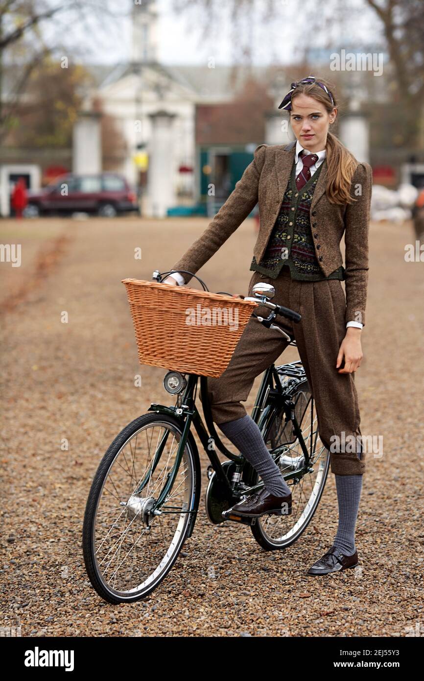 Junge schöne Frau auf Vintage-Fahrrad mit Korb Stockfoto