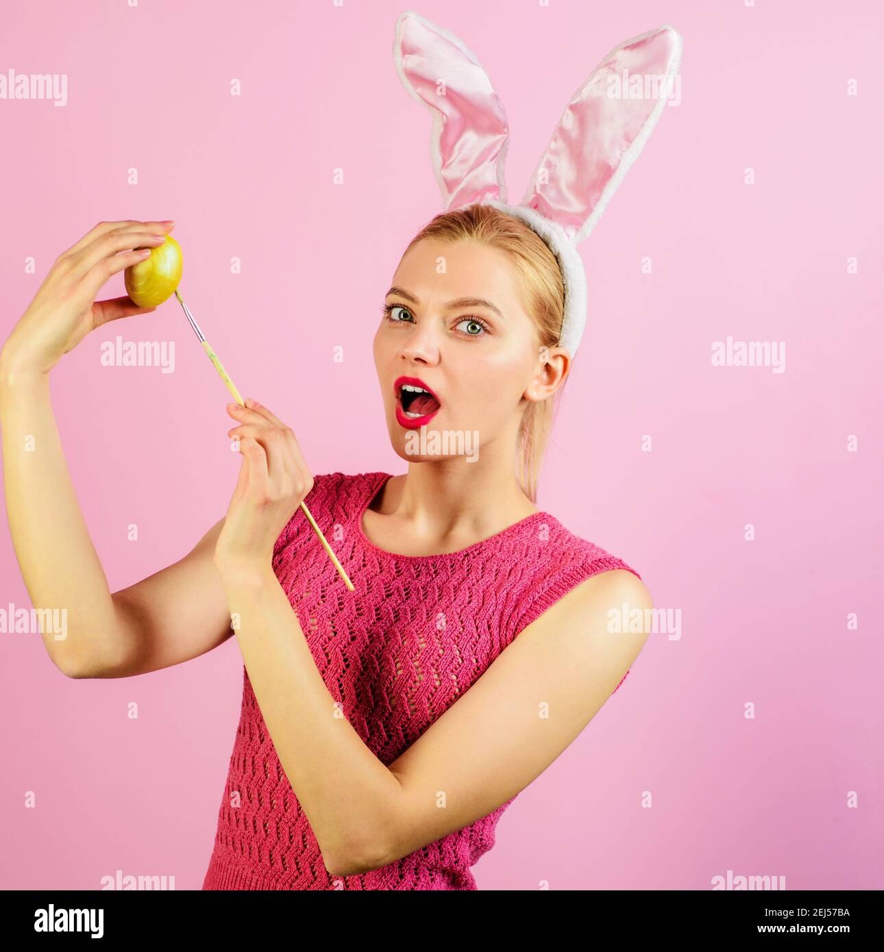 Frau in Hasen Ohren malen Ei. Frohe Ostern. Frühlingsferien. Stockfoto