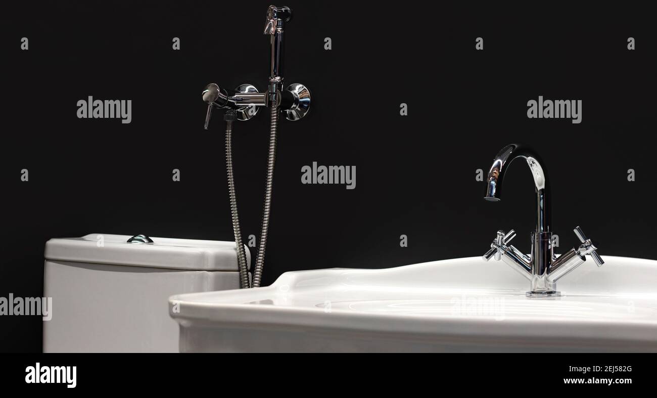 Foto von Toilette mit Wasserhahn, Waschbecken und WC-Dusche auf schwarzem  Hintergrund Stockfotografie - Alamy