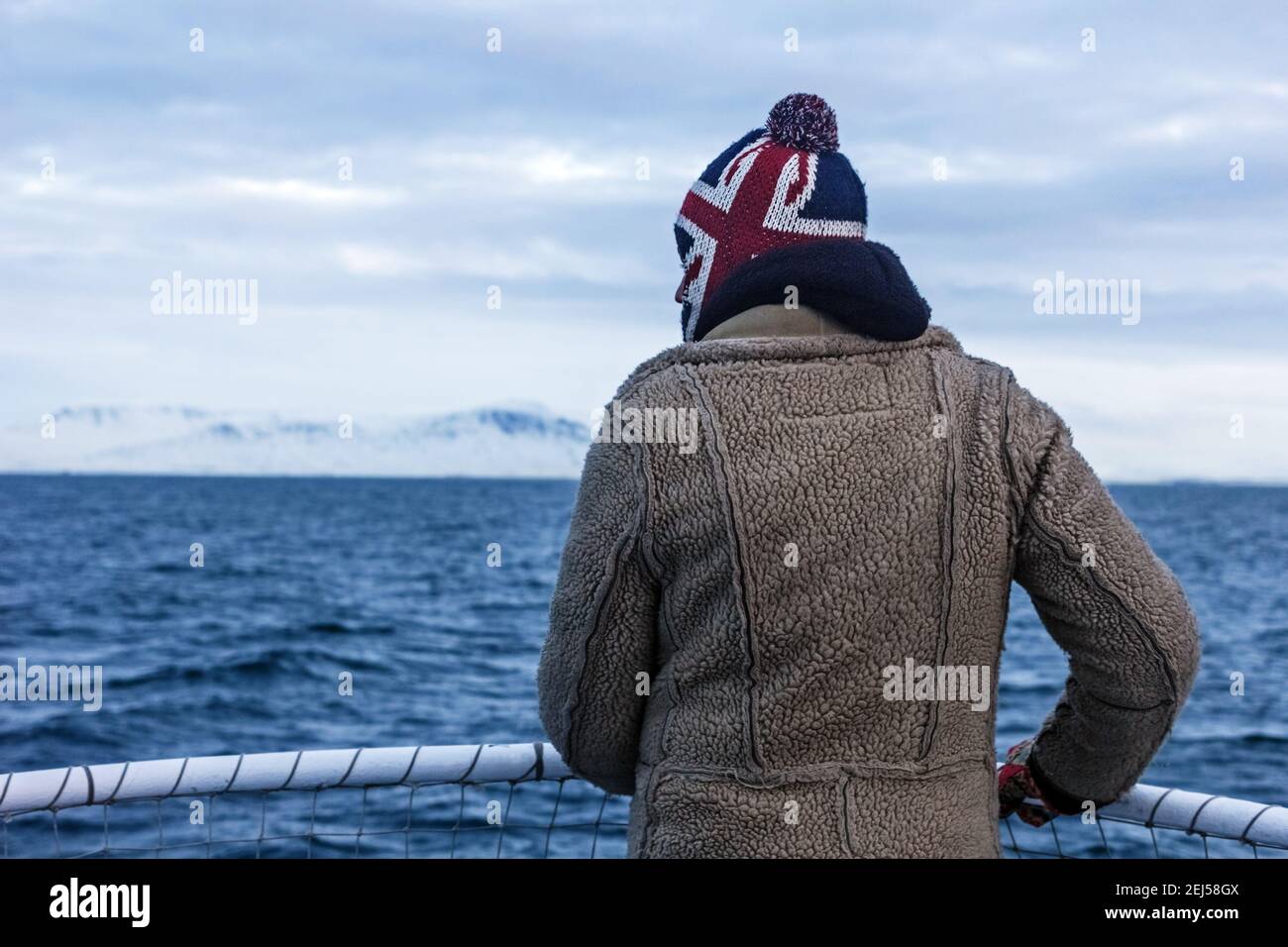 3. Januar 2016 - Atlantisches Ozeanschiff, Island; der echte Mann schaut in die Ferne auf schneebedeckte Berge und kaltes Meer Stockfoto 3. Januar 2016 - Atlantisches Ozeanschiff, Island; der echte Mann schaut in die Ferne auf schneebedeckte Berge und kaltes Meer Stockfoto