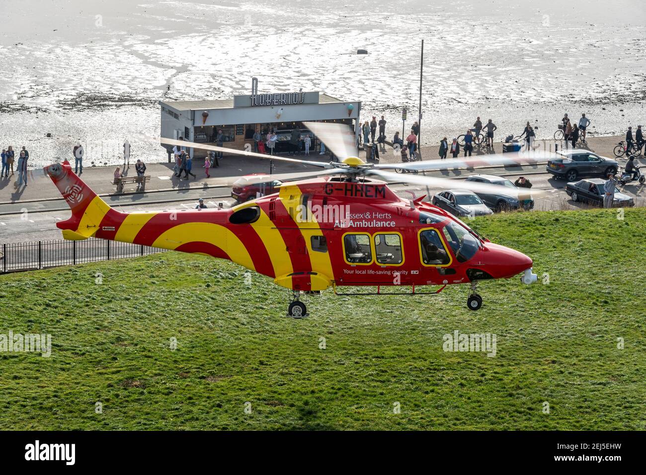 Essex & Herts Air Ambulance starten an einem Wintertag von Cliff Gardens in Southend on Sea, Essex, Großbritannien, während der COVID 19-Sperre. Menschen beobachten Stockfoto