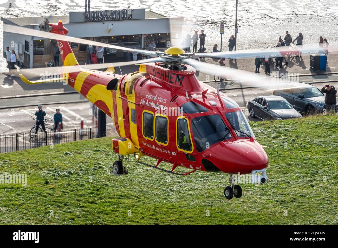 Essex & Herts Air Ambulance starten an einem Wintertag von Cliff Gardens in Southend on Sea, Essex, Großbritannien, während der COVID 19-Sperre. Menschen beobachten Stockfoto