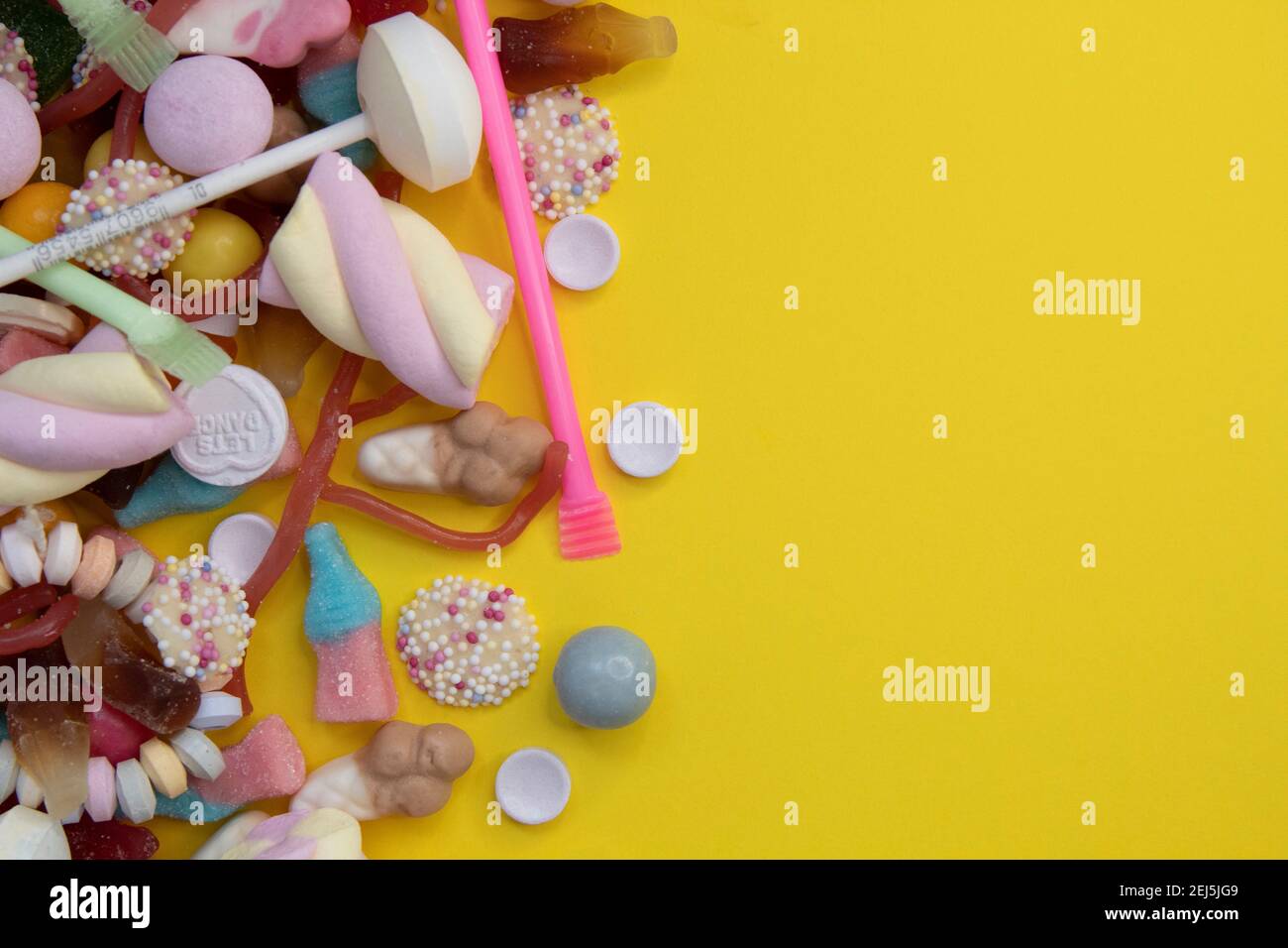 Blick von oben auf den Eiskegel mit Lollipop, Jellybeans und auslaufende Streuseln. Stockfoto