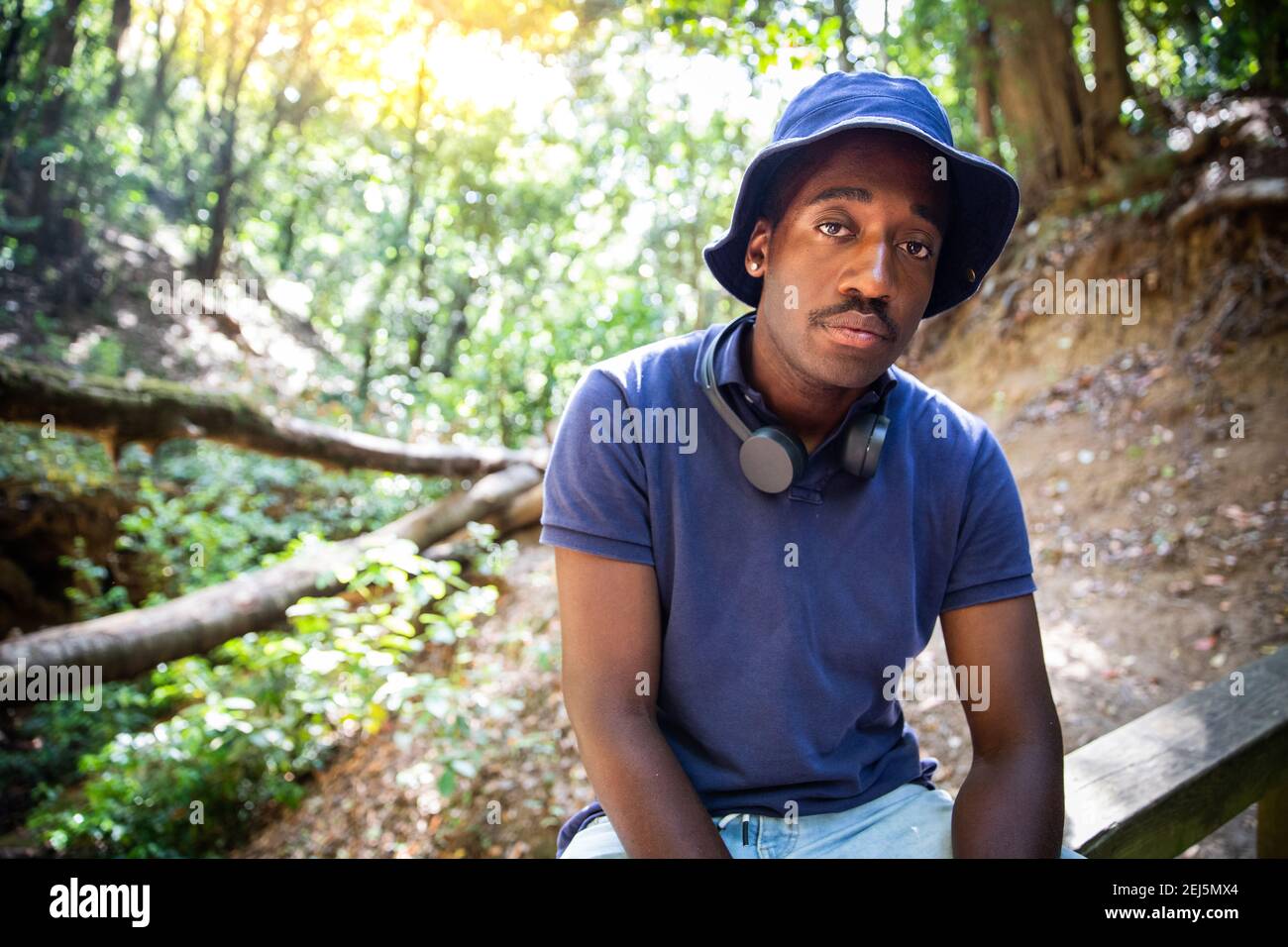 Serious stylish Junge ist in der Mitte eines Waldes Im Kontakt mit der Natur während einer Exkursion Stockfoto