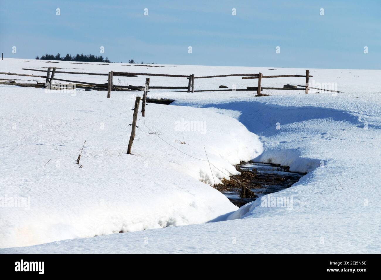 Schmelzendes Schneefeld, Weidezaunwiese, auftauende Schneeverwehungen Stockfoto