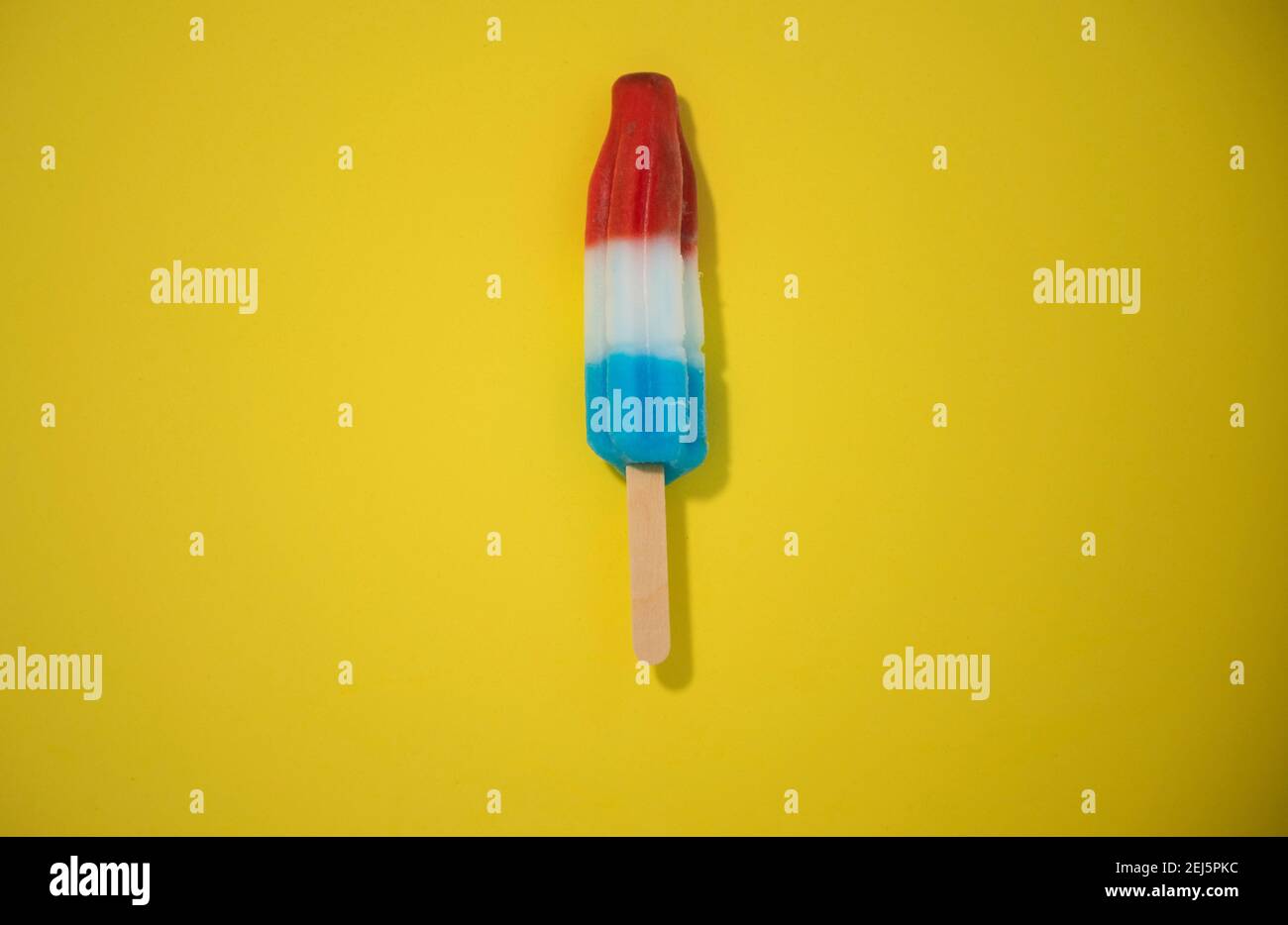 Rot, Weiß und Blau Neuheit Eis Bombpop auf gelbem Hintergrund geschossen, stoppen Action-Animation explodiert wie ein Feuerwerk. Serie 1 von 8. Stockfoto